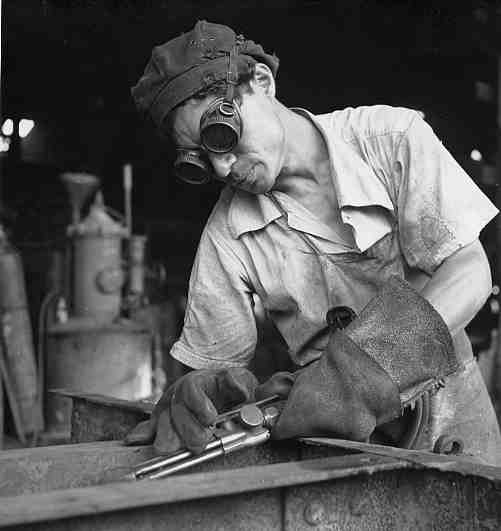 Trabajador soldando el marco de un tren de mercancías de la American Railroad Co. Porto Rico en San Juan, Puerto Rico 