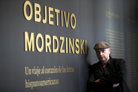 Título de la exhibición en la entrada de la galería con con artista.